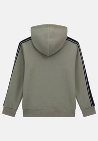 Tamsiai žalia gobtuvu megztinis su tekstūruotu audiniu. Su juodomis šoninėmis juostomis ir pūkuotais rankogaliais bei apačia. Klasikinis siluetas, kasdienis stilius.