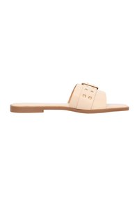 Sandali piatti beige con una larga fascia caratterizzata da elementi in oro e borchie decorative, realizzati in materiale morbido con un design minimalista.