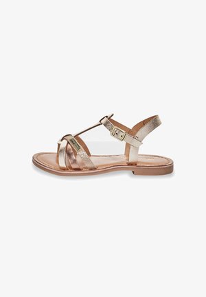 Metallisch gouden sandalen met bandjes en een T-bandontwerp, platte zool en verstelbare enkelgesp. Glad leren afwerking met kruisbanden.
