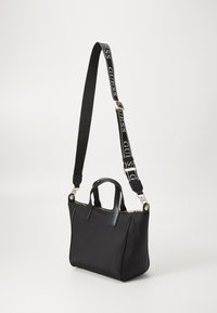 Borsa nera con forma strutturata, materiale in tessuto, manici doppi e tracolla regolabile con un design del logo. Dettagli in metallo oro.