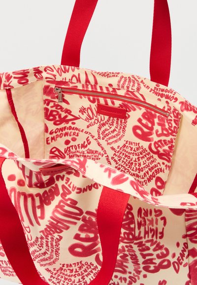 Sac fourre-tout en toile avec poignées rouges et motifs de texte motivationnel manuscrit rouge à l'intérieur et à l'extérieur, comprenant une poche zippée.