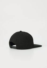 Black cotton cap with an adjustable plastic strap, curved brim, and a rounded top, featuring ventilation eyelets. Simple design with no patterns.