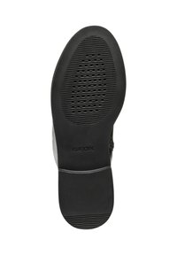 Suela de zapato de goma negra con textura antideslizante, que presenta líneas grabadas horizontales y verticales. Logo "GEOX" grabado en el lateral.