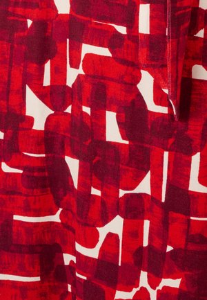 Patrón geométrico abstracto en tonos rojo y granate sobre tela con formas rectangulares y ovaladas superpuestas sobre un fondo blanco.