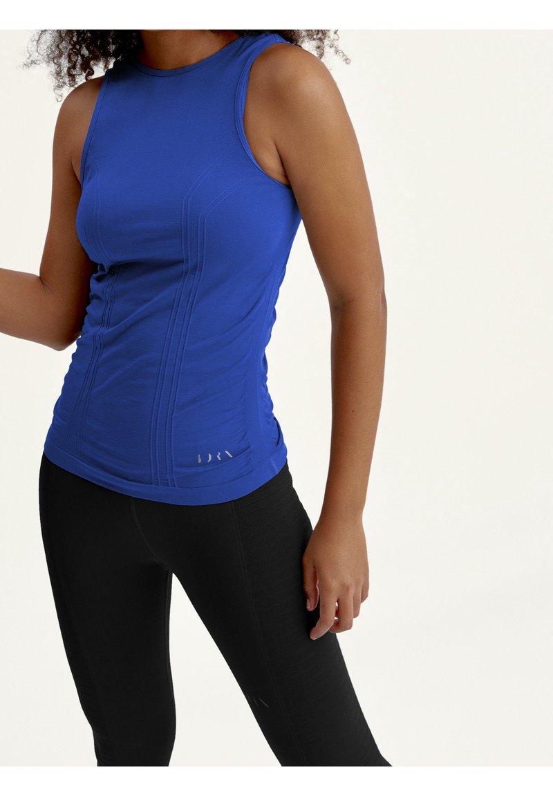 Blue sleeveless athletic top with a fitted design, textured fabric, and subtle stitching details, paired with black athletic leggings.