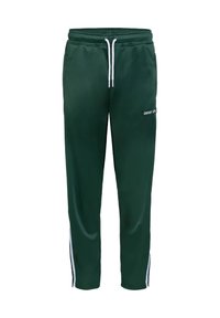 Pantalon de sport vert foncé avec taille à cordon blanc, rayure latérale et petit texte "UNFAIR ATHL" sur la cuisse supérieure.