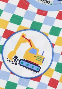 Short-sleeve T-shirt with a colorful checkered pattern. Features a circular patch with a yellow excavator graphic on a blue background.