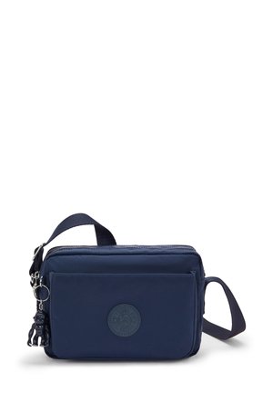 Navy blue nylon crossbody bag with a zip closure, front pocket, and a detachable keychain accent. Features a round logo patch.
