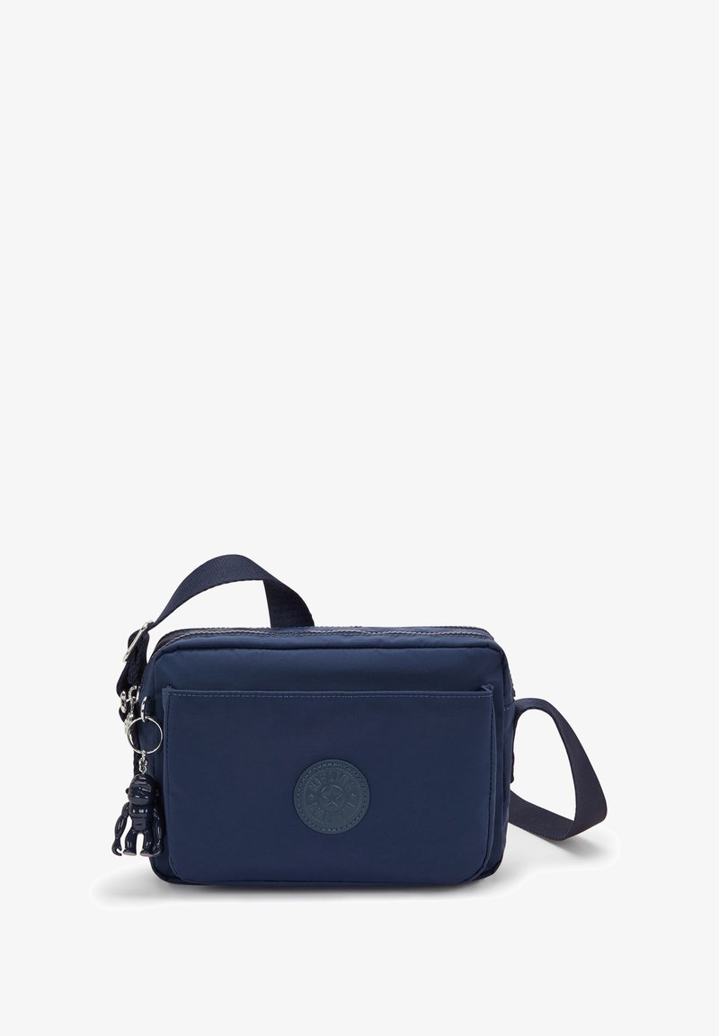 Borsa a tracolla in nylon blu navy con chiusura a zip, tasca frontale e un accento con portachiavi staccabile. Presenta una toppa rotonda con logo.