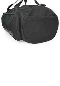 Bolsa de lona cilíndrica negra con un bolsillo de malla en el extremo, compartimento lateral con cremallera y correa de hombro ajustable.