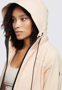 Light pink hooded jacket with black accents, featuring a zip closure and a logo, made of smooth, lightweight material.