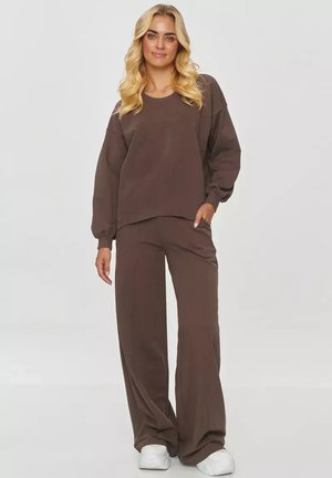 Brązowy, luźny sweatshirt i pasujące szerokie spodnie, wykonane z miękkiego materiału, z długimi rękawami i prostym wzorem.
