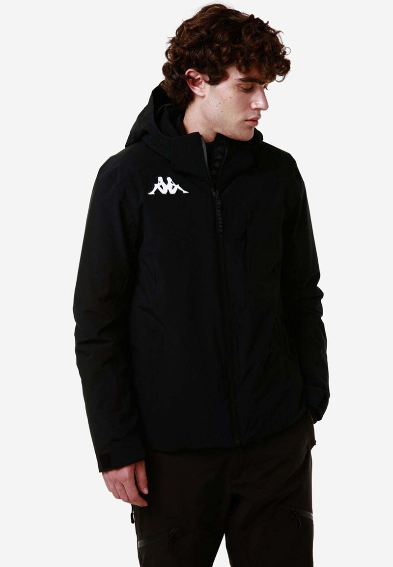 Giacca nera con zip e cappuccio, con un logo bianco sul petto e tessuto testurizzato. Design slim fit con polsini regolabili.