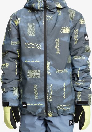 Enfant portant une veste d'hiver bleu gris avec des motifs abstraits jaunes et des gants et pantalons assortis, fermeture éclair avant fermée.