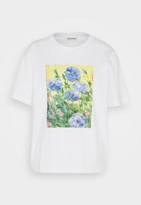Bílý tričko s barevným květinovým potiskem modrých květin na žlutém pozadí, krátké rukávy a uvolněný střih.