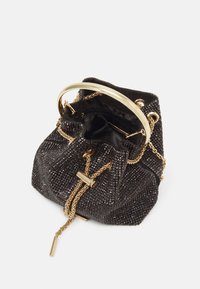 Sac seau en perles noires avec une poignée circulaire en or et des poignées en chaîne. L'intérieur est doublé de tissu noir avec une poche zippée.