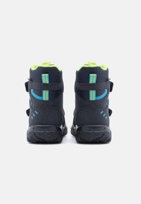 Svarte og grønne høye sneakers med teksturert materiale, borrelåser og blå detaljer på hælen og siden.