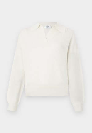 Baltas megztinis su V formos iškirpte ir per dideliu apykaklės kraštu. Įrengti raukiniai apačioje ir rankogaliuose. Minkštas audinys ir laisvas kirpimas.