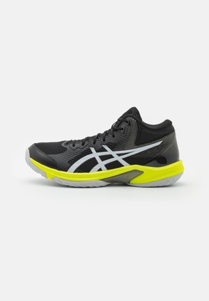 Scarpa da ginnastica nera con tomaia in rete, dettagli riflettenti in argento e suole gialle brillanti. Presenta un collo imbottito e una punta testurizzata.