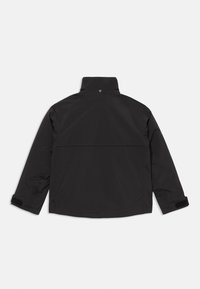 Schwarze Langarmjacke mit hohem Kragen, Druckknopf auf der Rückseite und verstellbaren Handgelenkriemen mit Klettverschluss.