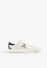 White leather sneaker featuring a grey skull and crossbones design, navy accent at the heel, and textured gray detailing on the side.