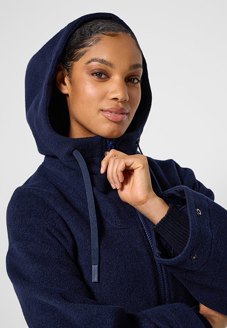 Marineblaues Kapuzenjacke mit Reißverschluss, weicher Textur und sichtbaren Kordelzügen. Beinhaltet Druckknopfverschlüsse und gestrickte Bündchen.