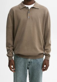 Brauner Strickpullover mit Kragen und drei Knöpfen, kombiniert mit hellblauen Jeans. Das Kleidungsstück hat lange Ärmel und eine lockere Passform.