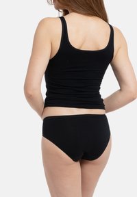 Zwarte katoenen tanktop met een fitted ontwerp, gecombineerd met bijpassende zwarte slips. Gladde textuur en een eenvoudige, praktische stijl.