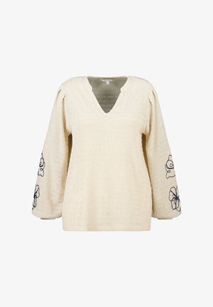 Roomkleurige blouse met lange mouwen in een crèmekleurige stof, voorzien van een V-hals en marineblauwe bloemenborduursels op de mouwen.