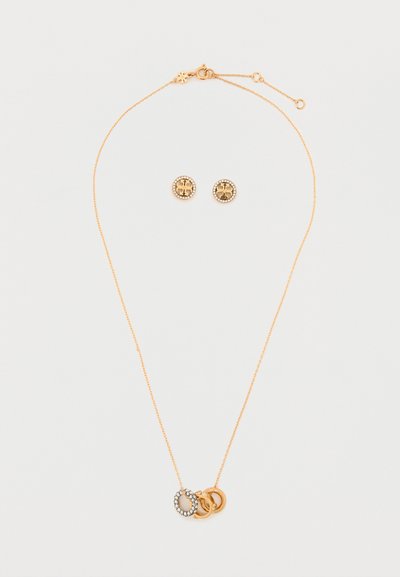 Collar tono dorado con tres anillos entrelazados, uno de los cuales presenta un acento de piedra. Pendientes de botón redondos a juego con detalle de círculo y piedra.