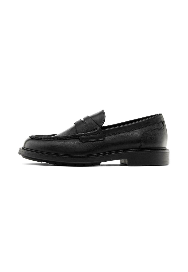 Black leather loafers with a rounded toe, stitched detailing, and a flat rubber sole. Features a front strap design.