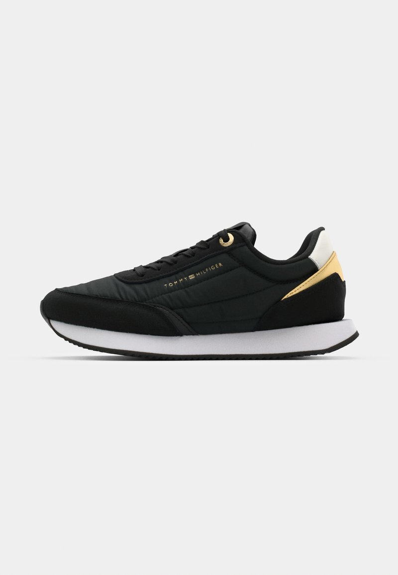 Czarne sportowe sneakersy z wyściełanym wierzchem, złotymi akcentami i białą podeszwą środkową. Oferują teksturowaną podeszwę zewnętrzną i minimalne oznaczenia marki.