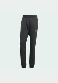 Pantaloni da jogging neri Adidas con elastico in vita, tasche laterali, polsini a coste e logo Adidas bianco sulla coscia sinistra.