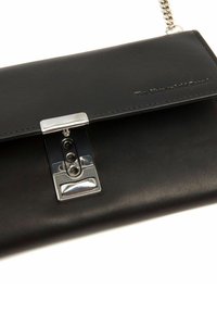 Borsa a pochette in pelle nera con chiusura metallica argento e tracolla a catena, con un delicato marchio impresso nell'angolo della patta.
