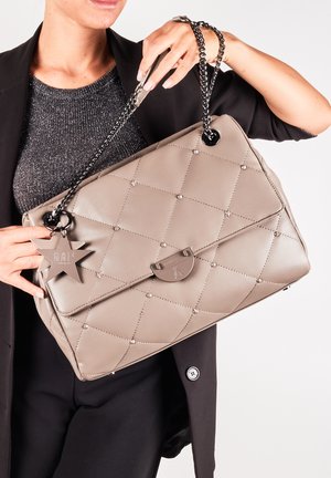 Vaaleanbeige pehmustettu käsilaukku, jossa on kiiltävä pinta, hopeinen ketjuolkalaukku, tähti-tyylinen koriste ja etuosassa napin sulku.