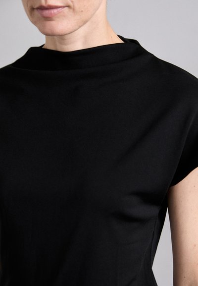 Black garment with a soft, smooth texture. Features a high, folded collar and short sleeves, highlighting a simple, elegant design.