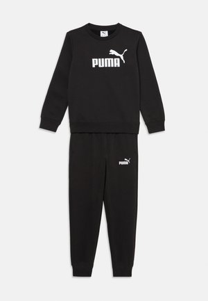 Juodos sportinės kelnės ir megztinis, pagaminti iš švelnios medžiagos. Megztinis turi baltą "PUMA" logotipą ir jaguaro detalę priekyje, kelnės turi logotipą ant klubo.