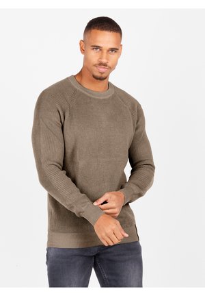 Olive green ribbed sweater with long sleeves, crew neckline, and textured fabric. Features a fitted hem and side slits.