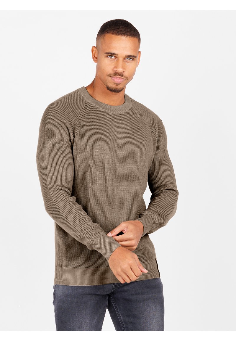 Olivgrüner gerippter Pullover mit langen Ärmeln, Rundhalsausschnitt und strukturiertem Stoff. Verfügt über einen figurbetonten Saum und seitliche Schlitze.