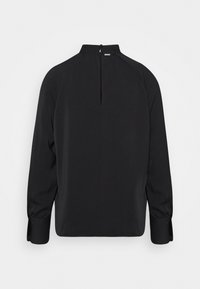 Blouse noire à manches longues avec col montant, fermeture par boutons à l'arrière du cou et larges poignets à détails boutonnés.