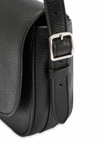 Czarna skórzana torba na ramię o teksturowanym wykończeniu, z metalowym zapięciem w kolorze srebrnym oraz regulowanym paskiem. Okrągły kształt z prostymi liniami.