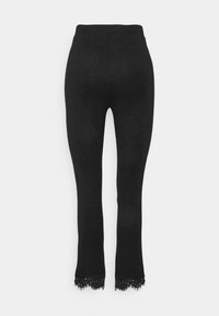 Zwarte elastische leggings met een aansluitend ontwerp en een kanten rand aan de onderkant. Gladde textuur en een hoge tailleband voor comfort.