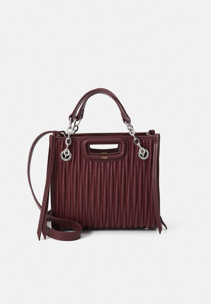 Bordeaux leren handtas met ribbelstructuur, hardware in zilvertint, bovenhandvatten, een afneembare schouderriem en een opvallend uitsnijd ontwerp.