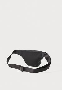 Bolsa de cintura em malha preta e tecido com tira ajustável e fecho de plástico, disposta plana sobre fundo branco.
