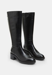 Botas de cuero negro hasta la rodilla con tacón de bloque y cremallera lateral. Textura suave, punta redondeada y diseño minimalista.