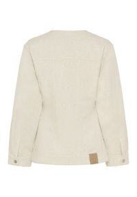 Lys beige denimjakke med struktureret design, lange ærmer, synlige sømme og et rektangulært mærke på nederste venstre ryg.