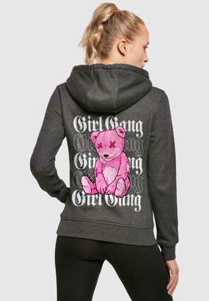 Mørkegrå hettegenser med et rosa kosedyrgrafikk med X-er for øyne og "Girl Gang" tekst i hvitt på baksiden. Myk bomullsblanding.