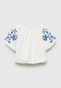 Vit linneskjorta med blå blommig brodyr på korta, vida ärmar, med en nyckelhålsöppning på baksidan och rund halsringning.