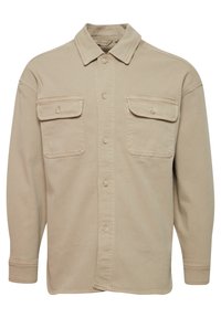 Beige button-up shirt made of cotton blend, featuring a pointed collar, two chest pockets, and long sleeves with buttoned cuffs.