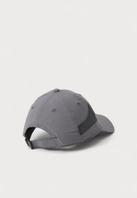 Gorra de tela gris con paneles laterales de malla, visera curvada y correa trasera ajustable. Presenta cierres a presión y orificios de ventilación.